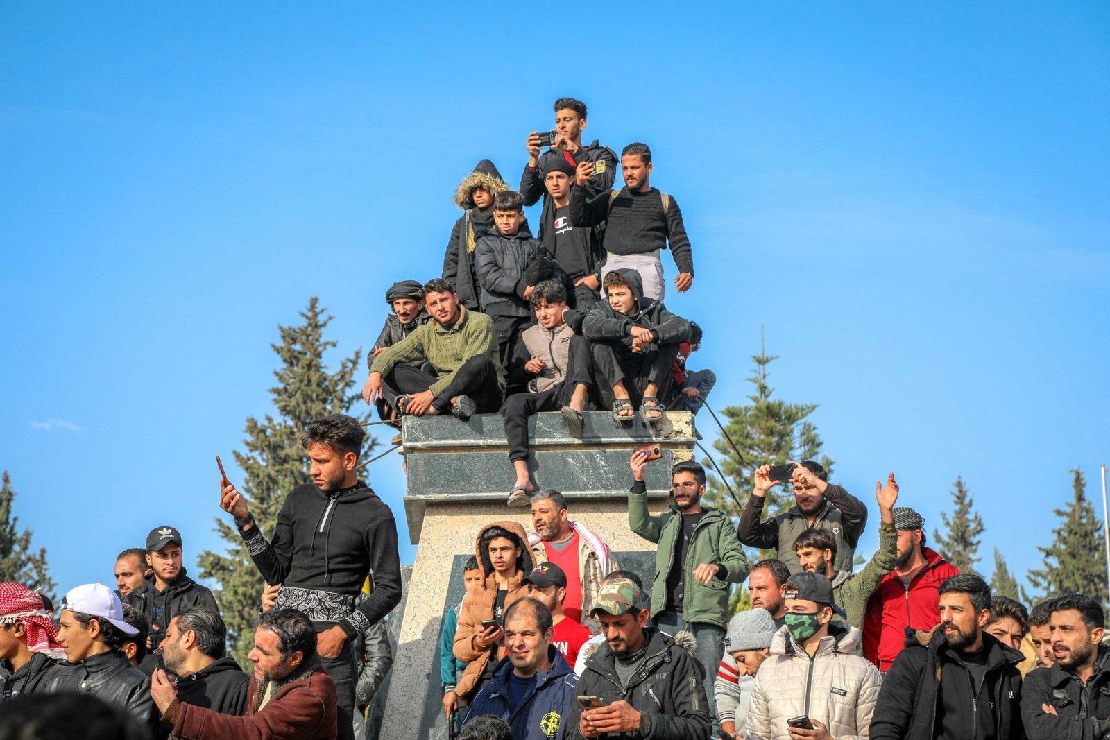 A group of people sitting on top of a monument